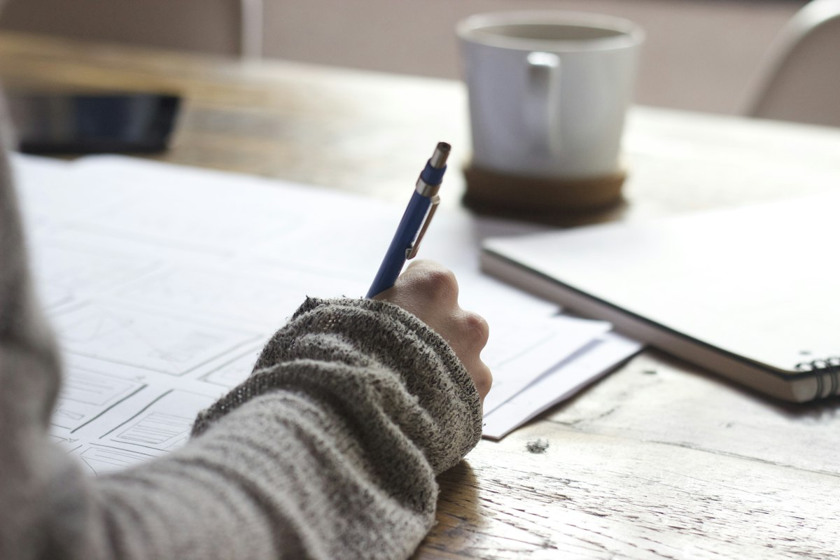 Person reviewing handwritten quarterly notes at a table